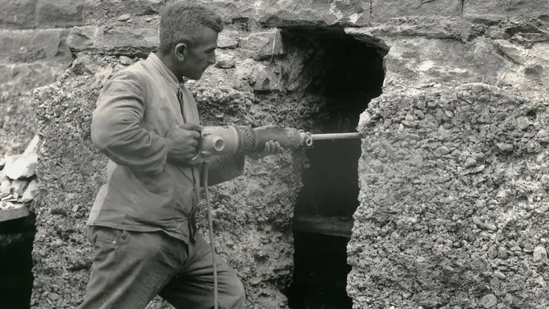 Historical picture of a craftsman chiseling into a wall with the Bosch hammer.