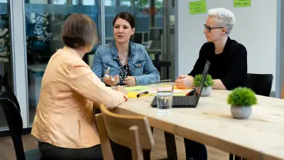 Three Bosch Power Tools associates sit together at a table and discuss.